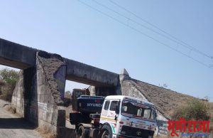 जेसीबी घेऊन जाणारा ट्रक रेल्वेब्रिजखाली अडकला!